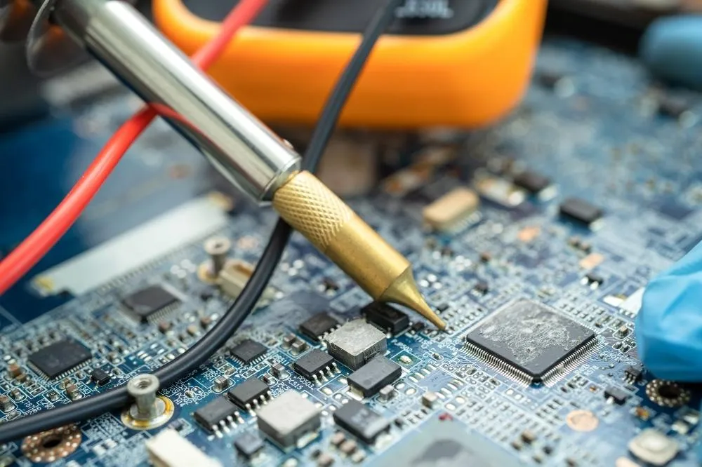 An HVAC technician testing the electrical components of a system.