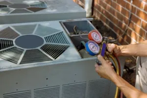 An AC repair expert is checking on the gas line of a system.
