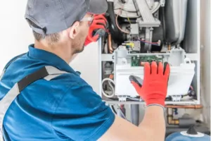 A heater repair specialist inspects the components of a system. 