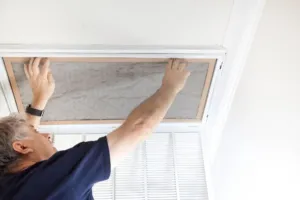An HVAC expert installs a new filter into a system for a customer after a furnace replacement.